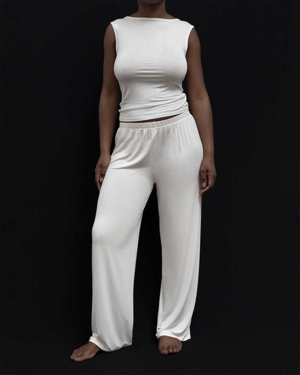 Model wearing Kye Recline Pant bamboo long pants in white. The loose fit and soft bamboo fabric offer a comfortable and stylish option for lounging or casual wear by Kye Intimates.