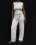Model wearing Kye Recline Pant bamboo long pants in white. The loose fit and soft bamboo fabric offer a comfortable and stylish option for lounging or casual wear by Kye Intimates.