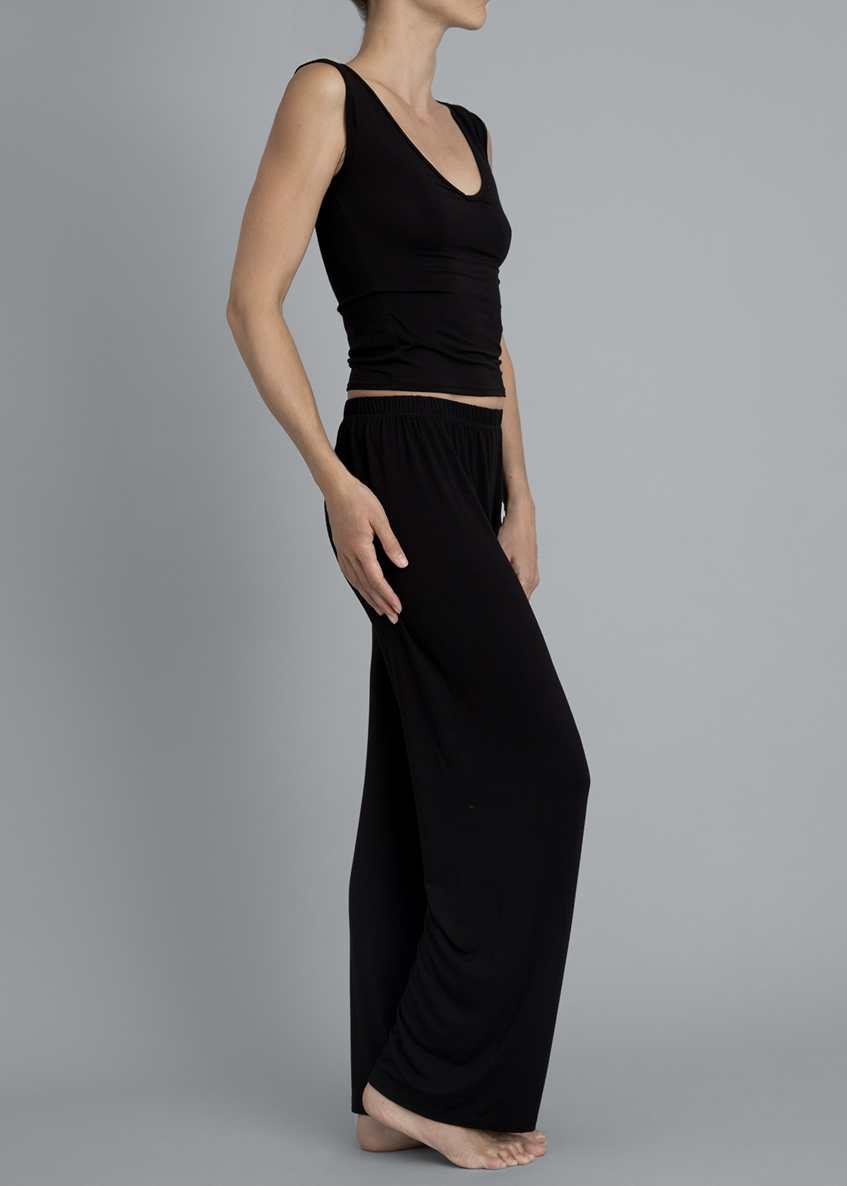 Side view of model wearing Kye Recline Pant bamboo long pants in black. The loose fit and soft bamboo fabric offer comfort and style, perfect for lounging or casual wear by Kye Intimates.
