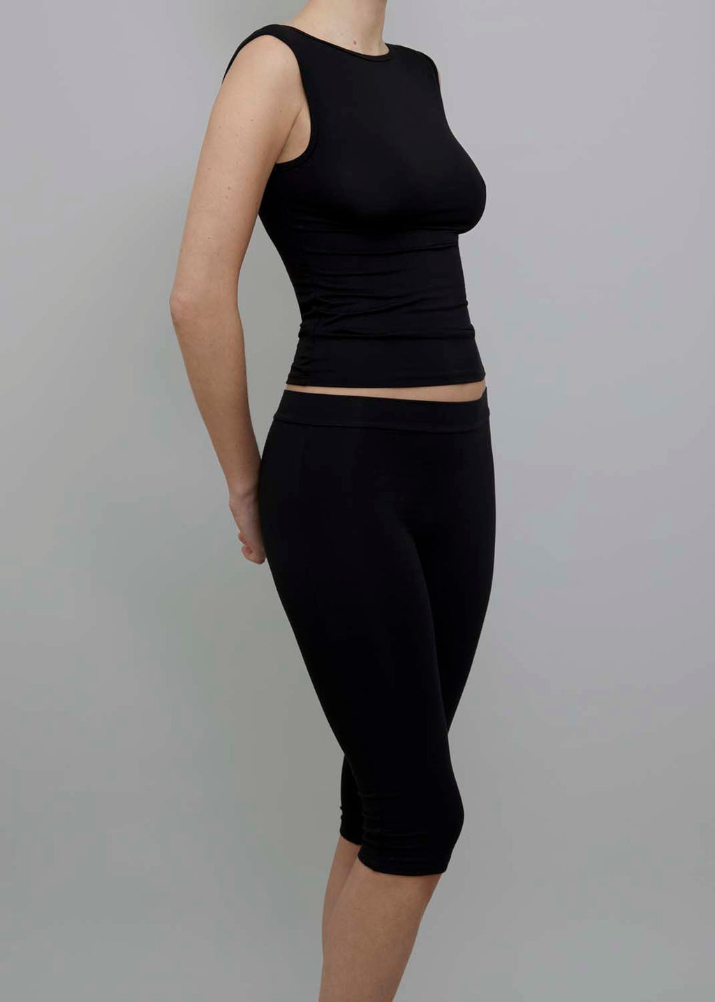 Side View of Capri Pant in Black, featuring a fitted silhouette. 