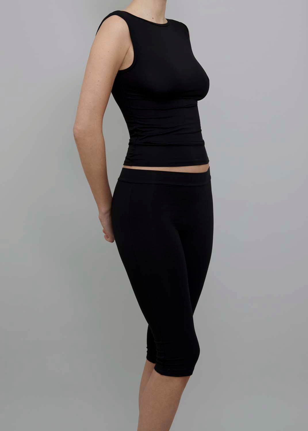 Side View of Capri Pant in Black, featuring a fitted silhouette. 