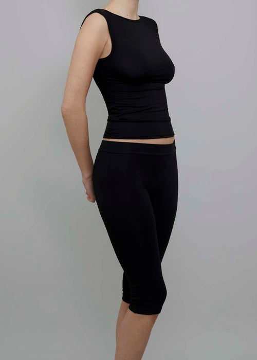 Side View of Capri Pant in Black, featuring a fitted silhouette. 