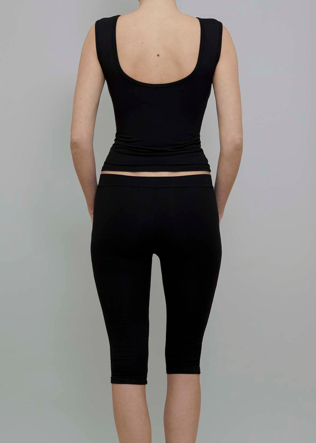 Back View of Capri Pant in Black, featuring a fitted silhouette. 