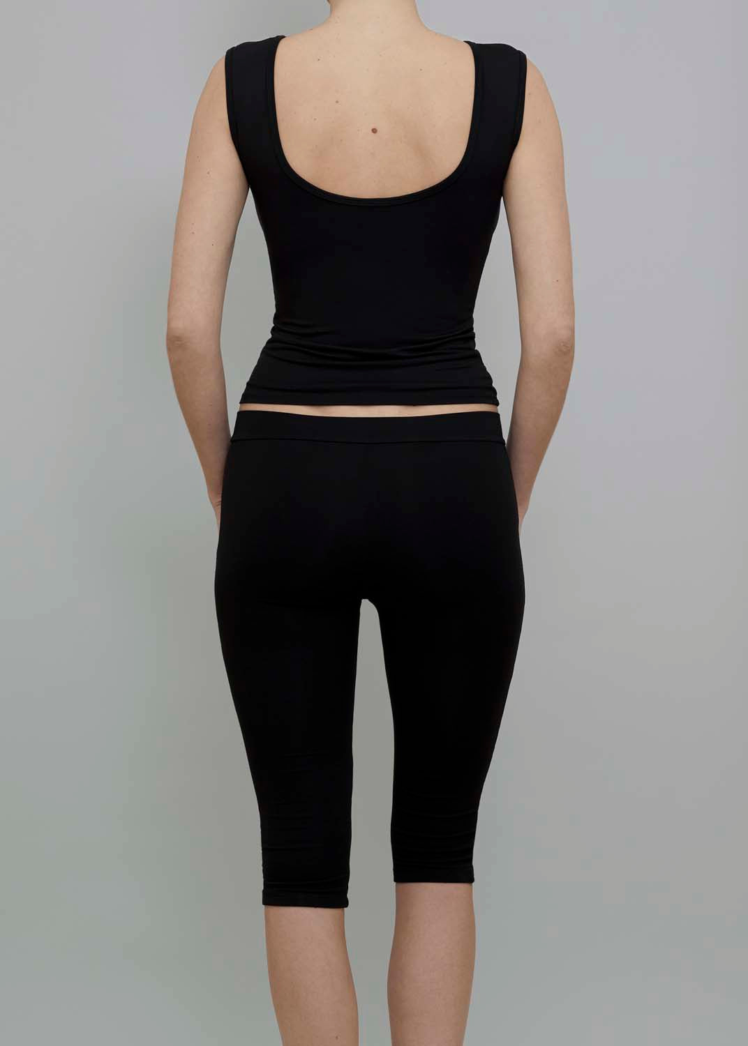 Back View of Capri Pant in Black, featuring a fitted silhouette. 