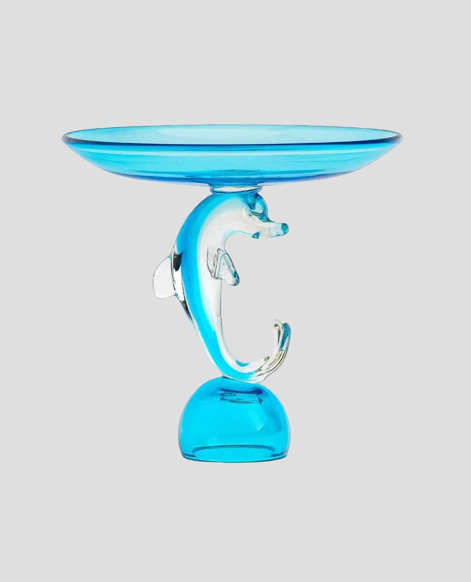 A translucent blue glass pedestal candle holder with a shallow saucer top and a sculpted dolphin-shaped center, shown on a plain white background.