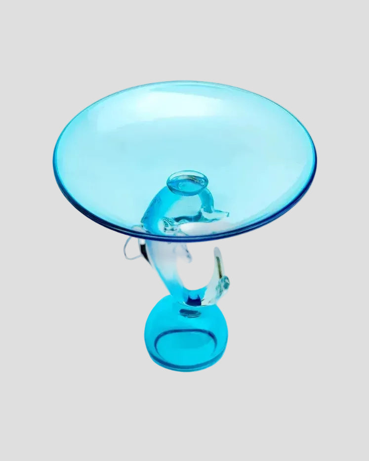 A translucent light blue glass pedestal table with a circular top and sculptural curved base, isolated on a white background.