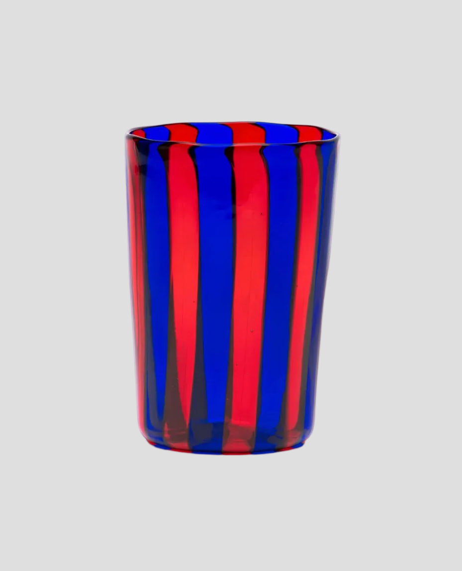 A tall, cylindrical glass tumbler with alternating vertical stripes of vibrant red and deep blue, shown on a plain white background.